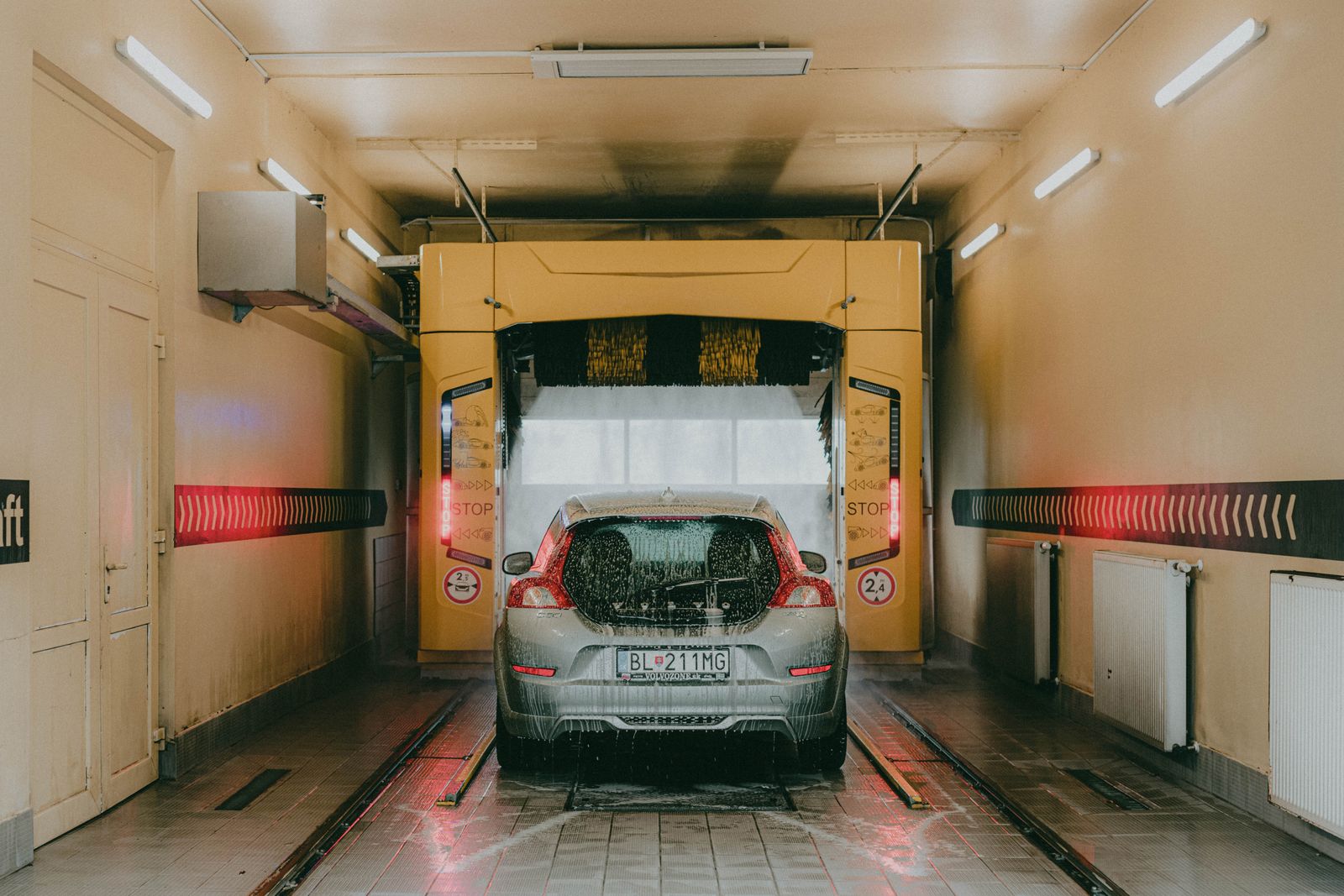 Vehicle inside a brightly lit automated car wash bay