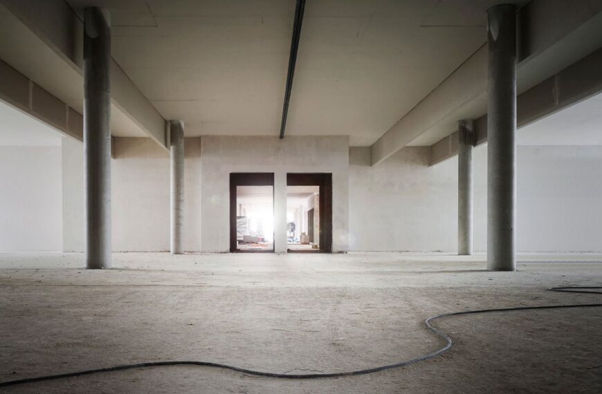Empty concrete industrial building interior with exposed columns, awaiting value-add renovation